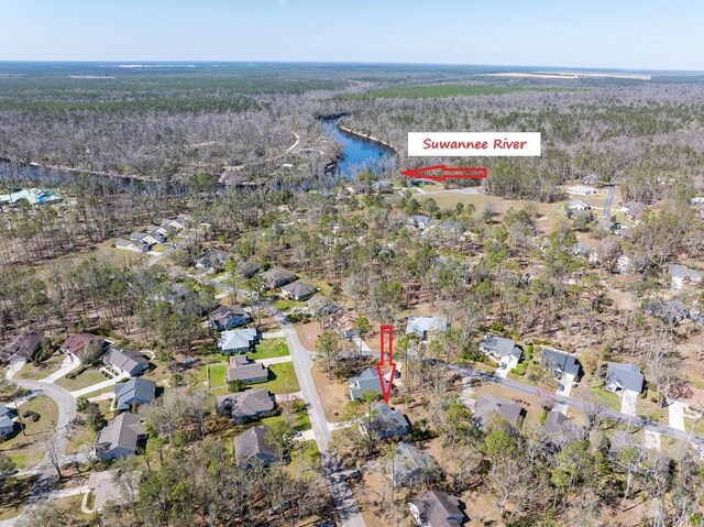 drone / aerial view featuring a wooded view and a water view