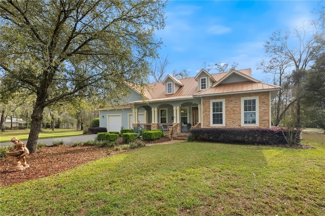 view of front of house featuring a porch, concrete driveway, an attached garage, a front yard, and metal roof