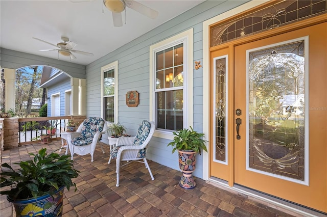 entrance to property featuring covered porch and ceiling fan