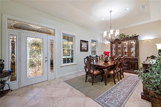 dining space with visible vents, baseboards, a tray ceiling, recessed lighting, and an inviting chandelier