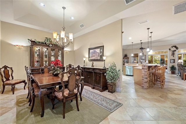 dining space with a tray ceiling, visible vents, a chandelier, and recessed lighting