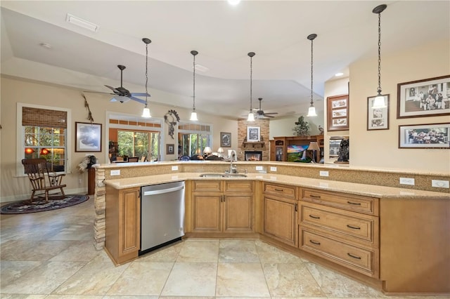 kitchen with a sink, light stone counters, stainless steel dishwasher, open floor plan, and ceiling fan