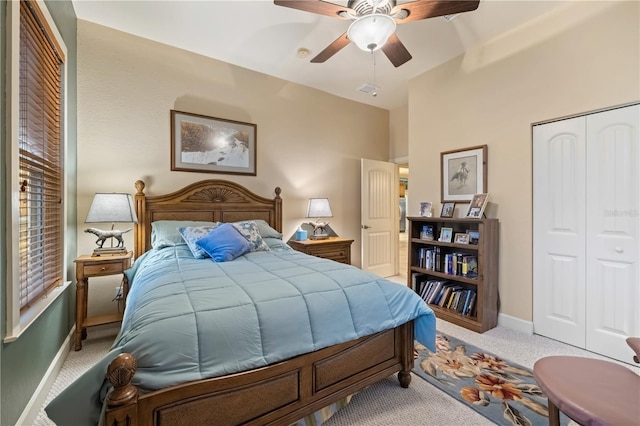 carpeted bedroom featuring a closet, baseboards, and ceiling fan