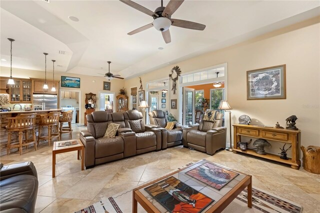 living room featuring visible vents, a raised ceiling, and a ceiling fan