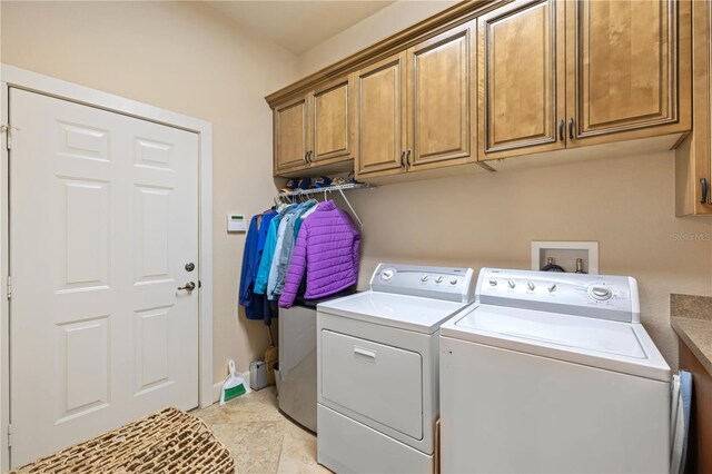 washroom with washer and dryer and cabinet space