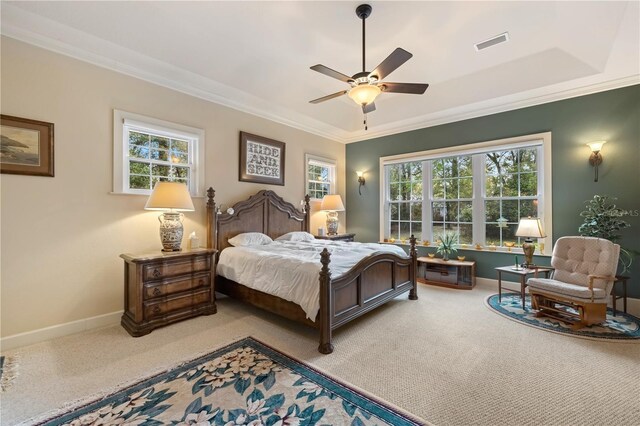 carpeted bedroom with visible vents, multiple windows, baseboards, and ornamental molding