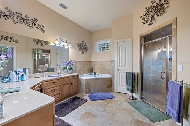 bathroom with visible vents, a garden tub, a stall shower, and vanity