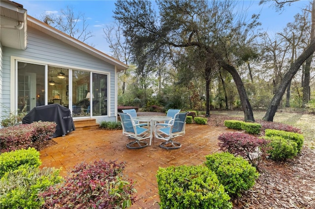 view of patio with outdoor dining area, a grill, and a sunroom