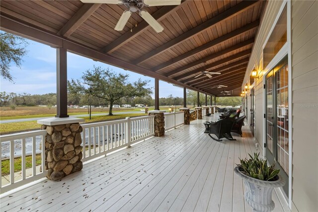 wooden terrace featuring covered porch and ceiling fan