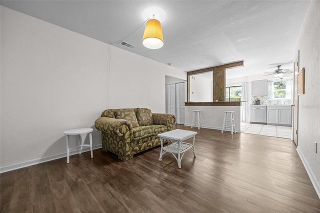 living area featuring wood finished floors, visible vents, and baseboards