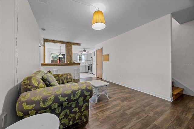 living area with ceiling fan, stairs, baseboards, and wood finished floors