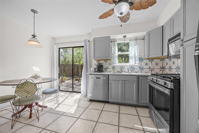 kitchen featuring stainless steel appliances, tasteful backsplash, gray cabinets, and hanging light fixtures