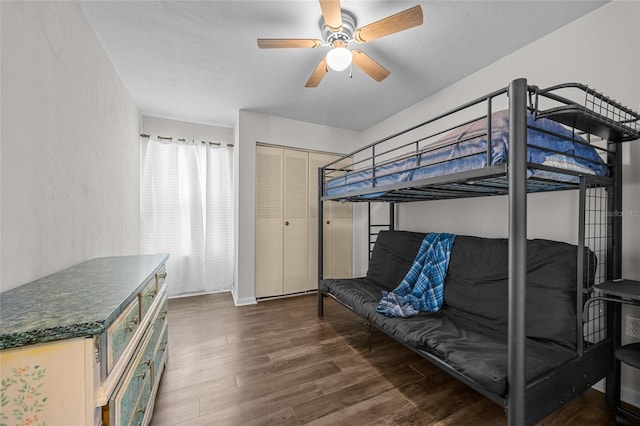 bedroom with a ceiling fan, dark wood-style flooring, and a closet