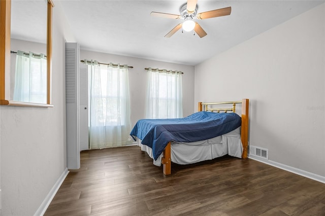 bedroom with ceiling fan, visible vents, baseboards, and wood finished floors