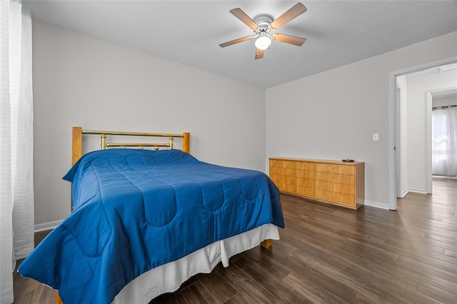 bedroom with baseboards, wood finished floors, and a ceiling fan