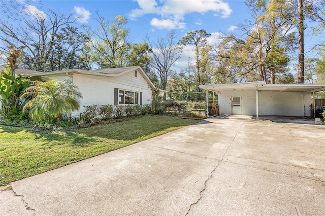 view of property exterior featuring a carport, concrete driveway, and a yard