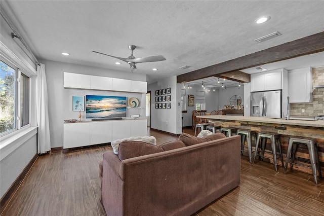 living area featuring baseboards, visible vents, recessed lighting, dark wood-style flooring, and ceiling fan