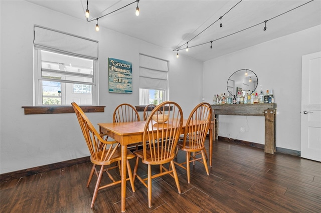 dining area with rail lighting, baseboards, and wood finished floors