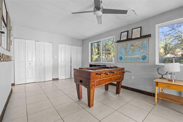 rec room featuring baseboards, light tile patterned flooring, and a ceiling fan