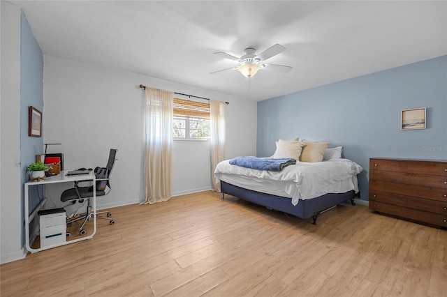 bedroom with a ceiling fan, wood finished floors, and baseboards