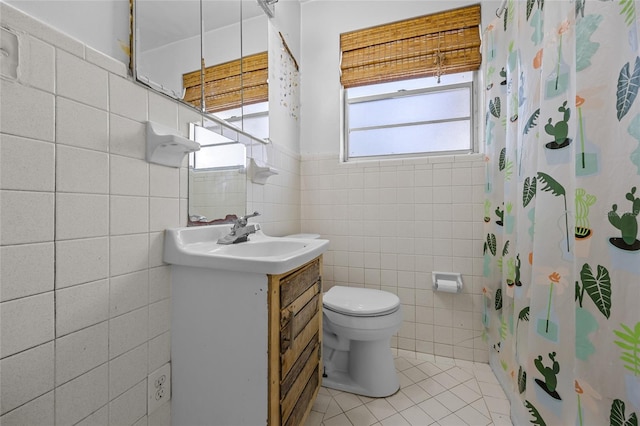 full bathroom featuring vanity, a shower with shower curtain, tile patterned floors, toilet, and tile walls