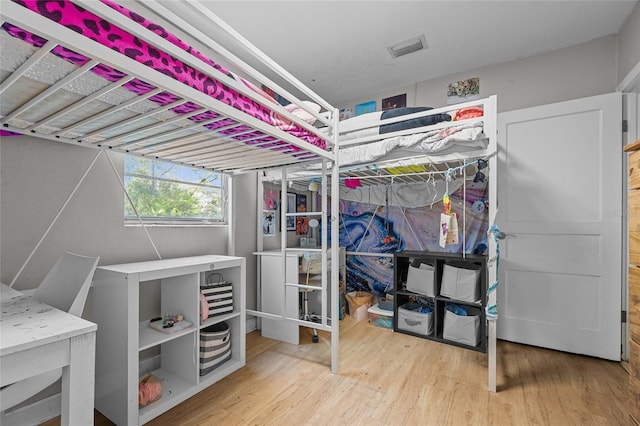 bedroom featuring wood finished floors and visible vents