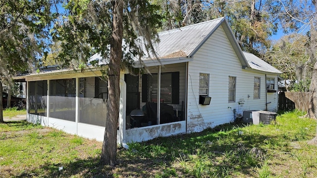 view of side of property featuring a sunroom, central AC, and metal roof