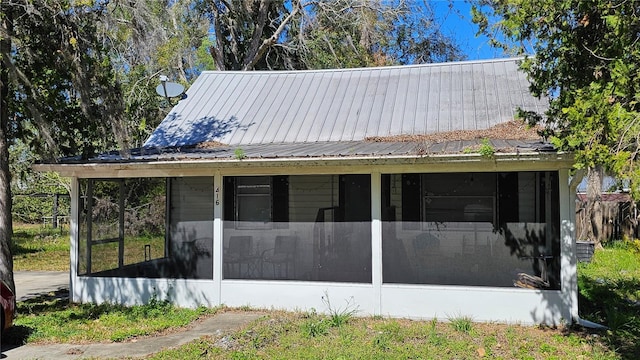 view of front of property featuring metal roof and a sunroom