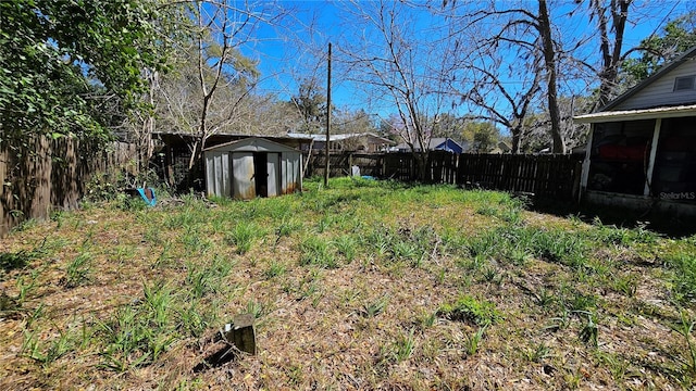 view of yard with an outdoor structure, a storage unit, and a fenced backyard