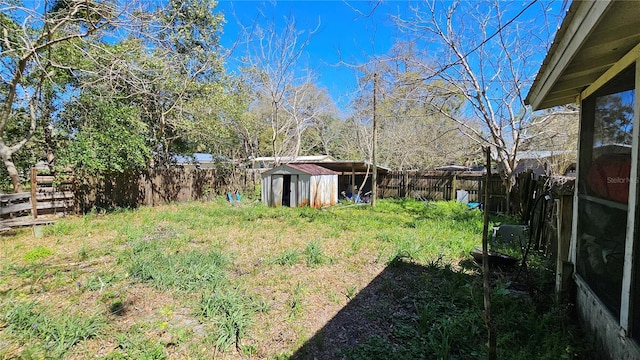 view of yard featuring a fenced backyard, a storage shed, and an outdoor structure