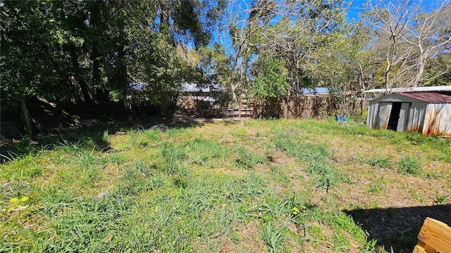 view of yard with fence, an outdoor structure, and a shed