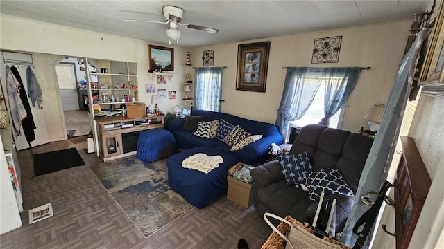 living area with visible vents and a ceiling fan