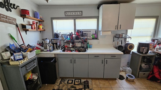 kitchen with a wealth of natural light, light tile patterned floors, light countertops, and open shelves