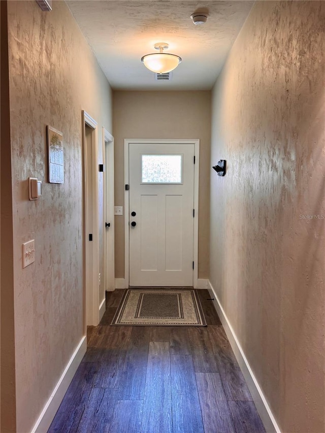 entryway featuring visible vents, baseboards, and wood finished floors