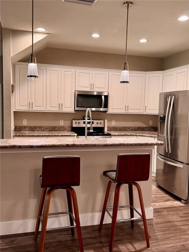 kitchen featuring white cabinets, light wood finished floors, appliances with stainless steel finishes, and pendant lighting