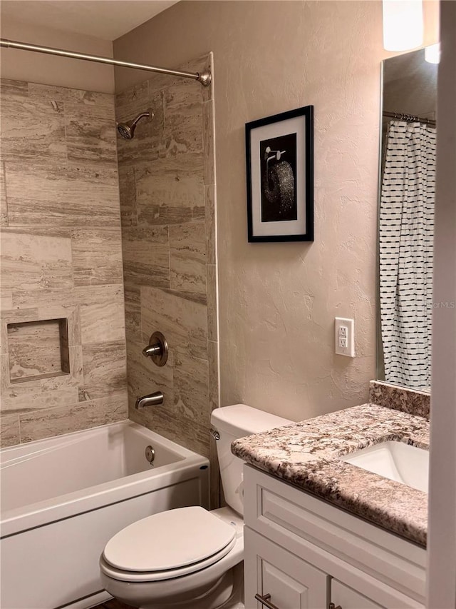 bathroom with vanity, toilet, a textured wall, and shower / bath combo with shower curtain