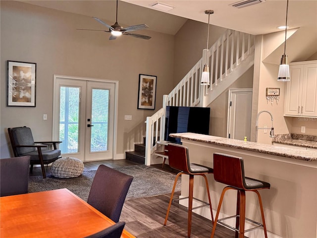 dining area with visible vents, stairs, french doors, ceiling fan, and dark wood-style flooring