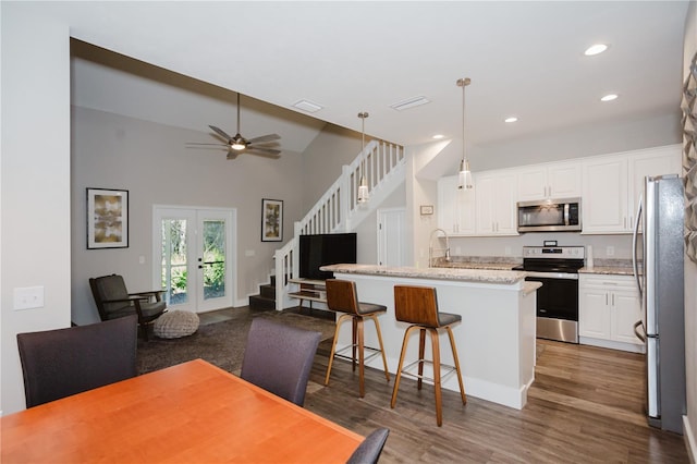 kitchen featuring visible vents, appliances with stainless steel finishes, wood finished floors, and white cabinetry