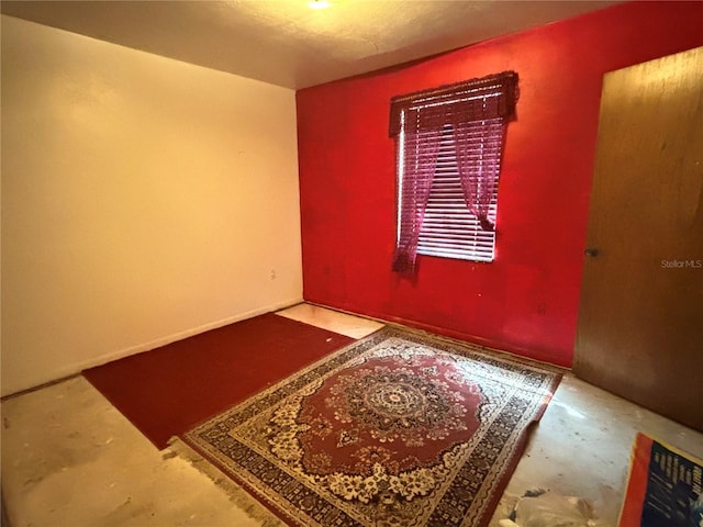 unfurnished room with unfinished concrete flooring