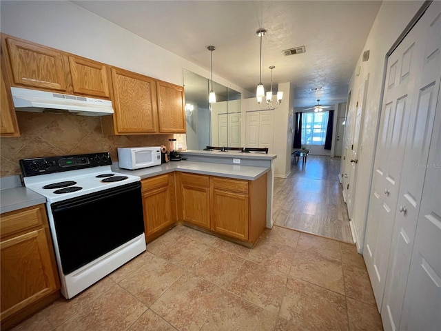 kitchen featuring white microwave, visible vents, under cabinet range hood, a peninsula, and electric stove