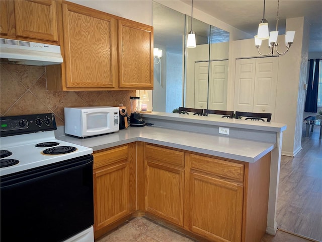 kitchen with electric stove, under cabinet range hood, backsplash, a peninsula, and white microwave