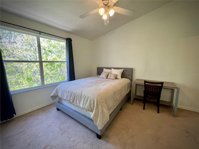 carpeted bedroom with vaulted ceiling, a ceiling fan, and baseboards