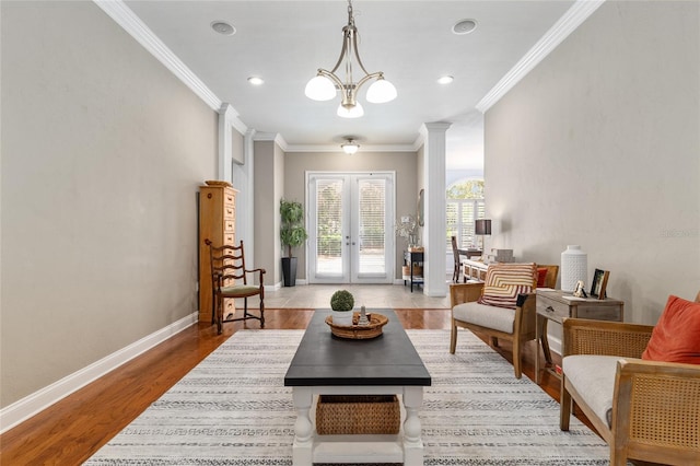 sitting room with wood finished floors, french doors, crown molding, baseboards, and ornate columns