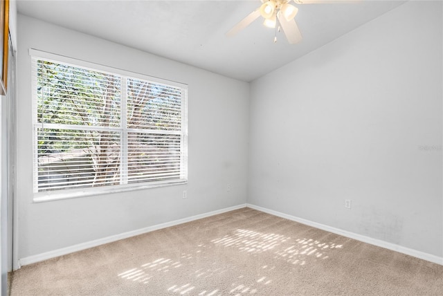 spare room with baseboards, carpet, ceiling fan, and vaulted ceiling