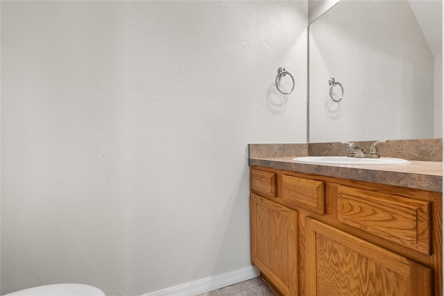 bathroom featuring vanity, tile patterned floors, toilet, and baseboards