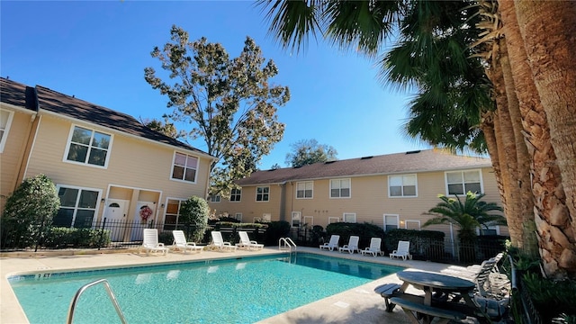 community pool featuring a patio area and fence