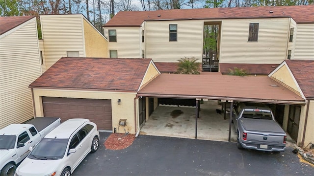 view of front of home with a garage, driveway, and stucco siding