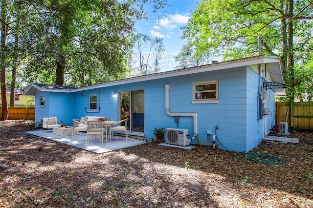 rear view of house featuring ac unit, fence, outdoor lounge area, central AC unit, and a patio area