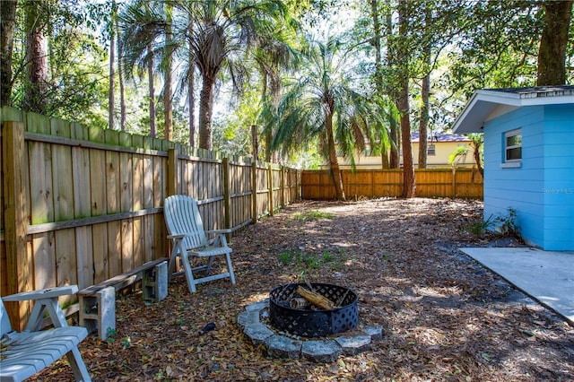 view of yard with a fenced backyard and an outdoor fire pit