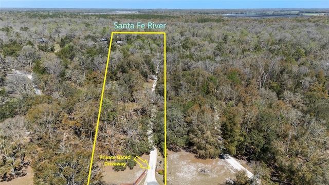 birds eye view of property featuring a view of trees